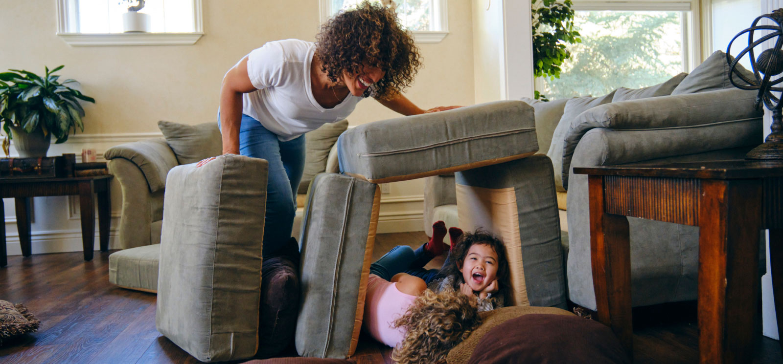 a mom looking at two young kids in a pillow fort