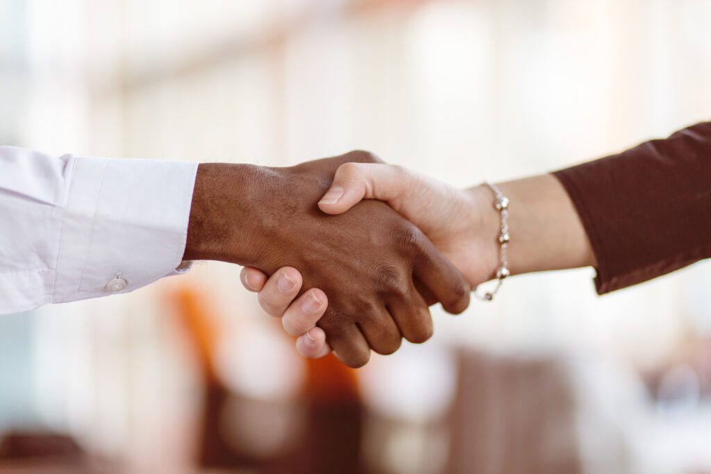 Two people shaking hands symbolizing credit union membership benefits, trust, and community-focused financial service