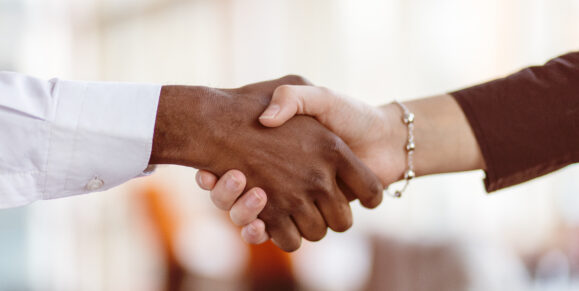 Two people shaking hands symbolizing credit union membership benefits, trust, and community-focused financial service